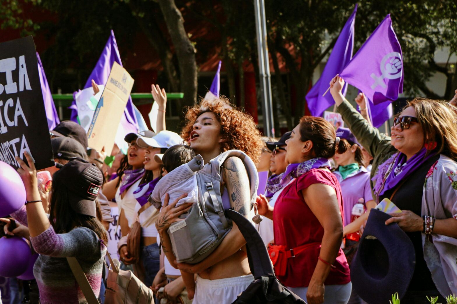Vibrant street march showcasing unity and feminism under vibrant purple flags.