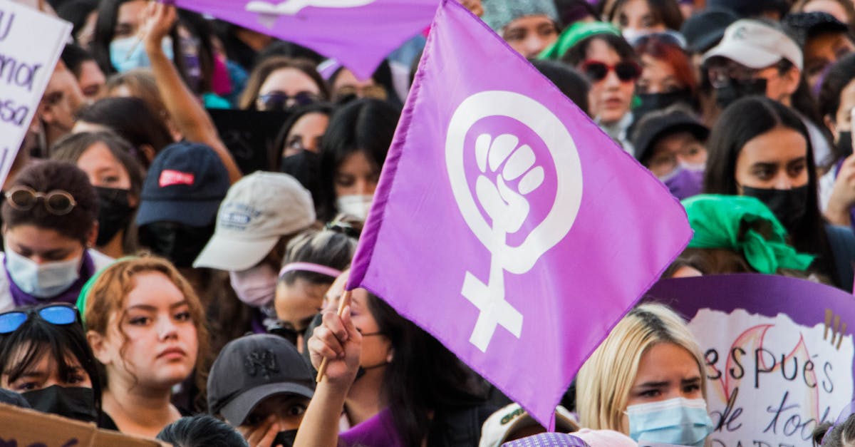 A passionate rally with women holding feminist symbols advocating for rights.